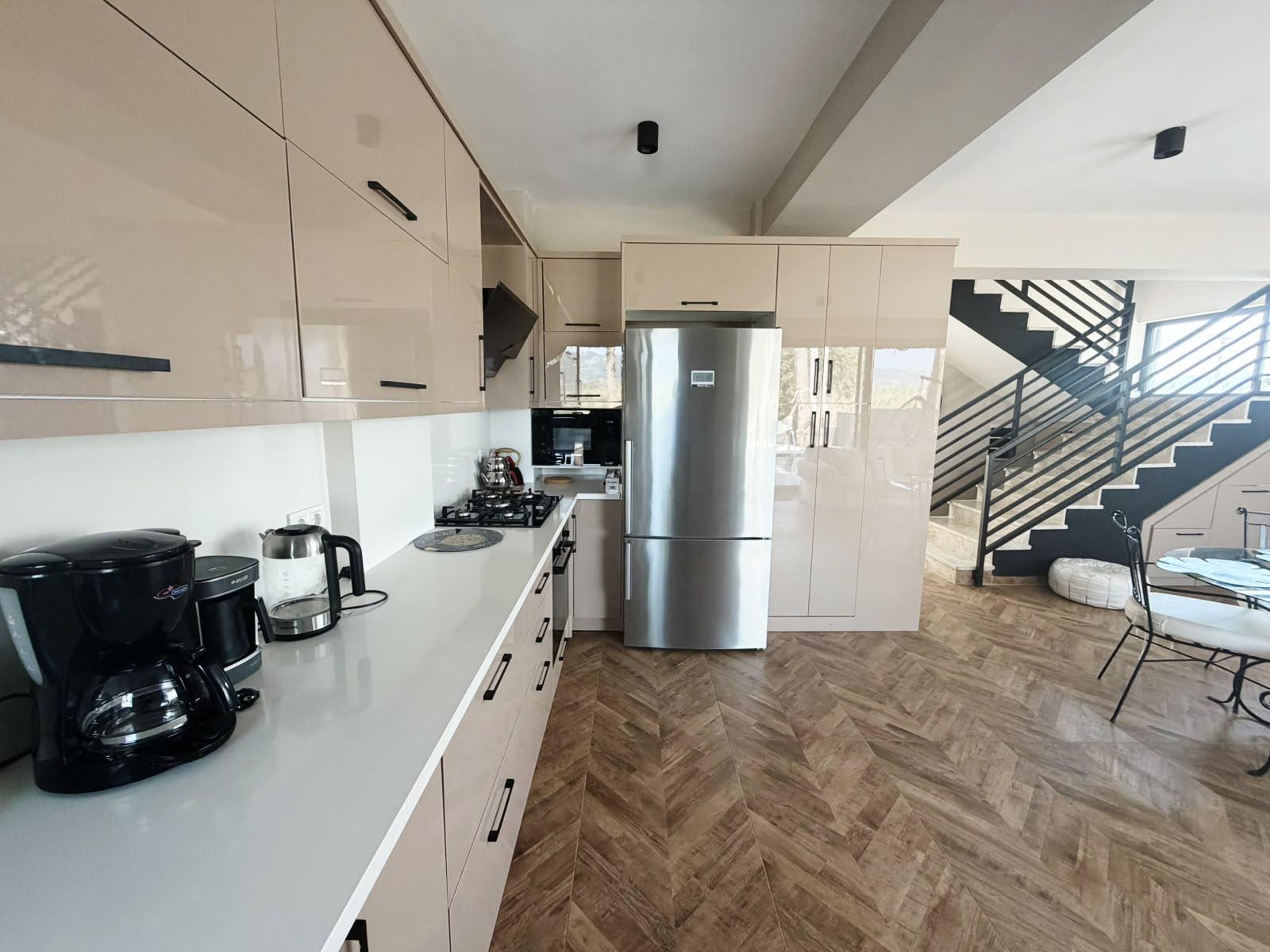 Kitchen with fridge-freezer and glossy cabinetry